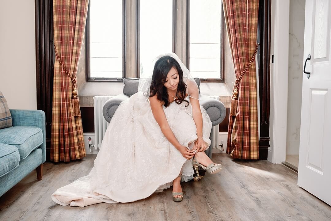 Bride putting on her shoes at Froyle Park