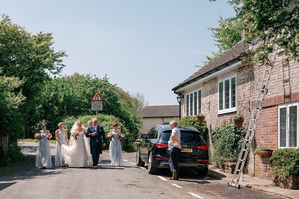 bride and bridal party walking to the church in Dorset