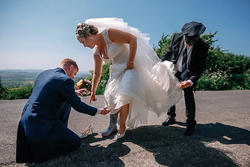 bride changing into wellington boots for couple portraits