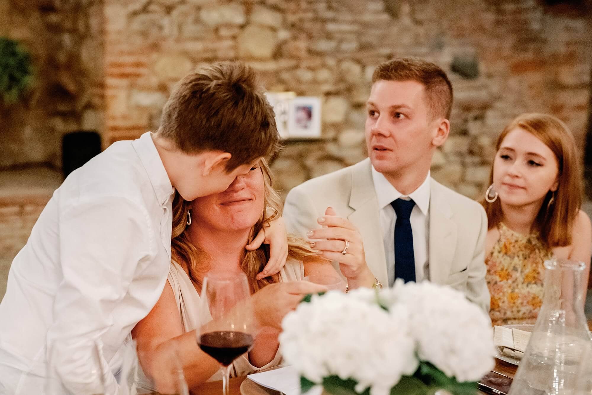 son comforting crying mum at Tuscany wedding