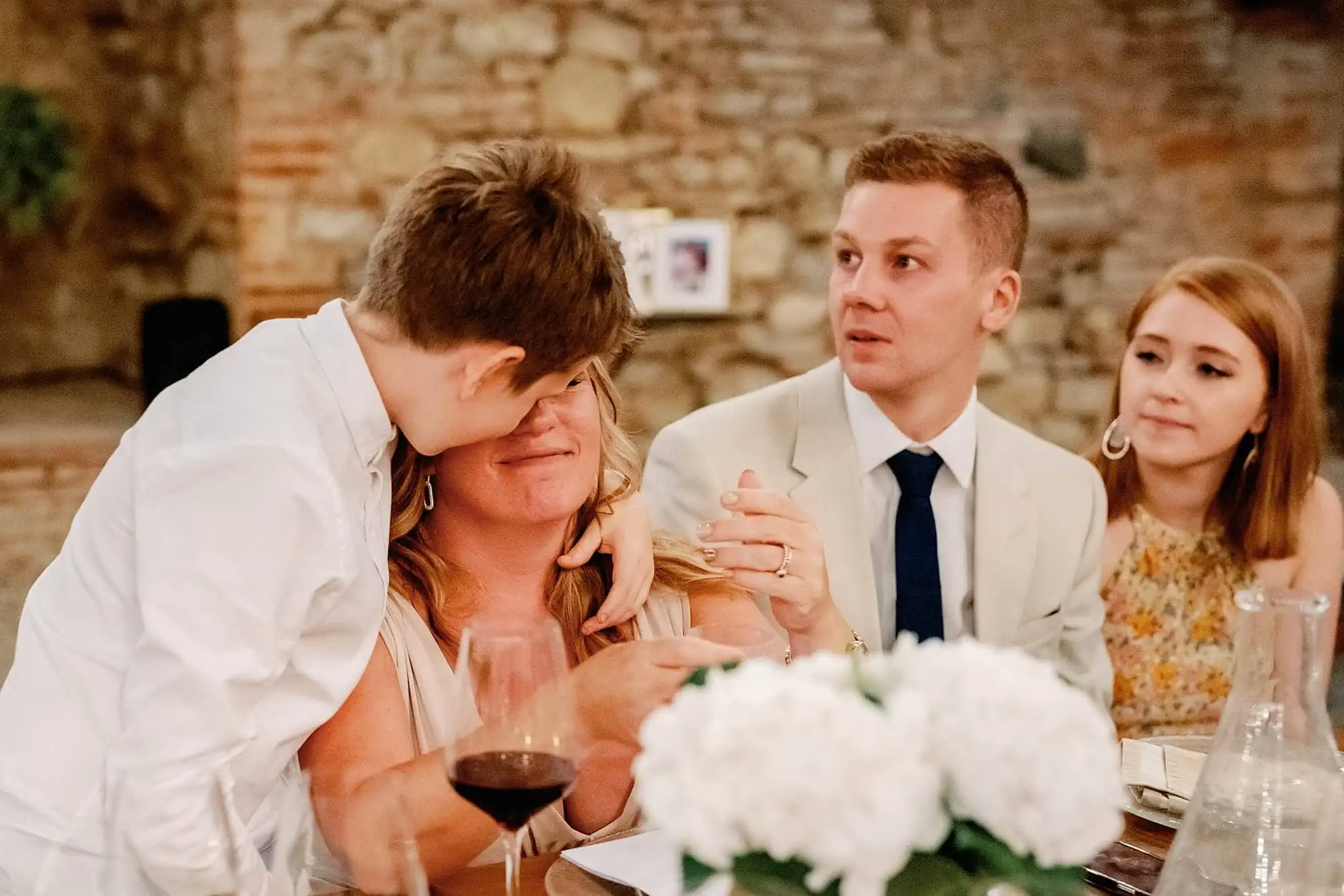 son comforting crying mum at Tuscany wedding