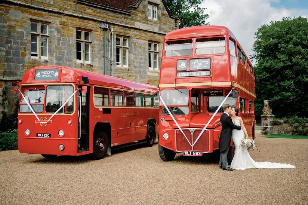 Couple in front of red London buses at Buckhurst Park Wedding Photography