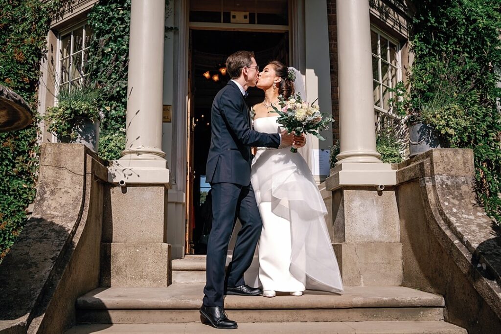 the bride and groom kissing outside the building