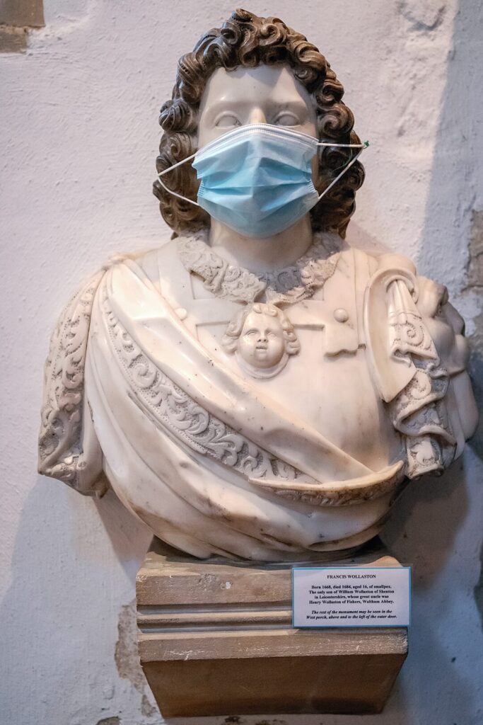 statue with a covid mask
