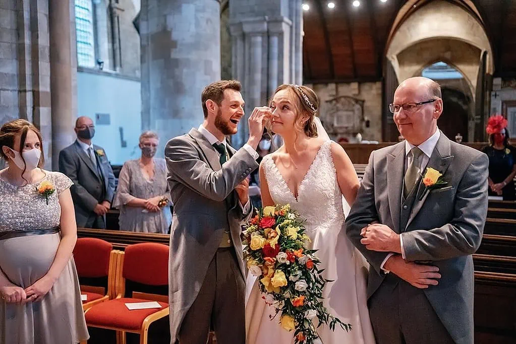 groom wiping away the bride's tears at Waltham Abbey