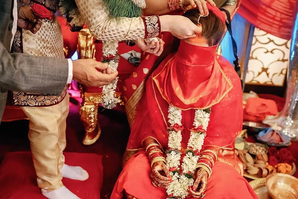groom adding tika on the bride