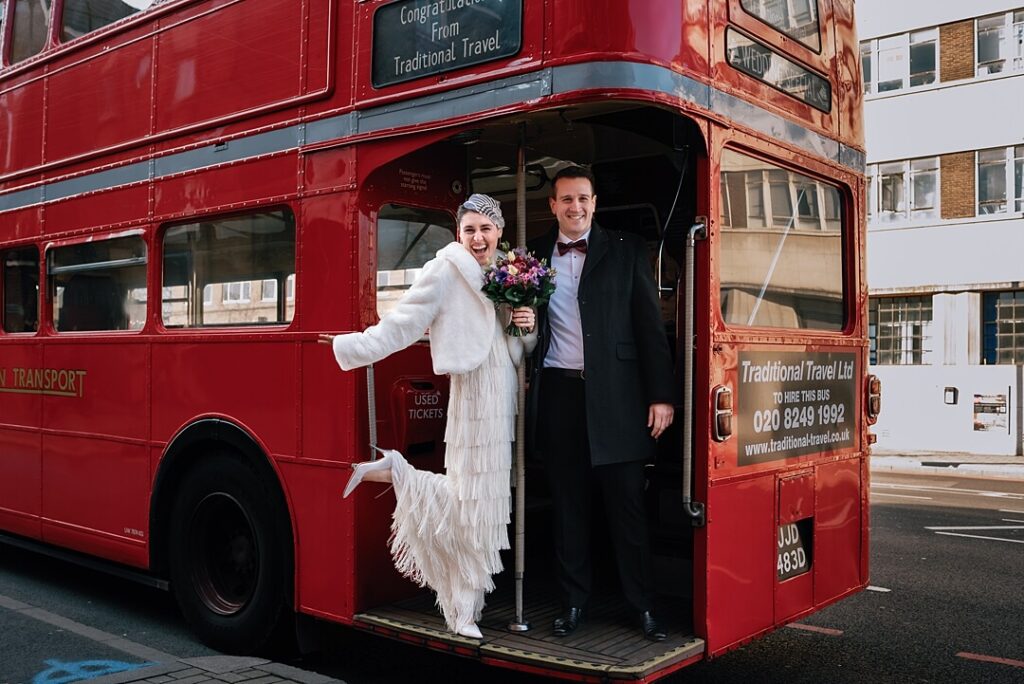 the bride and groom on a red London bus