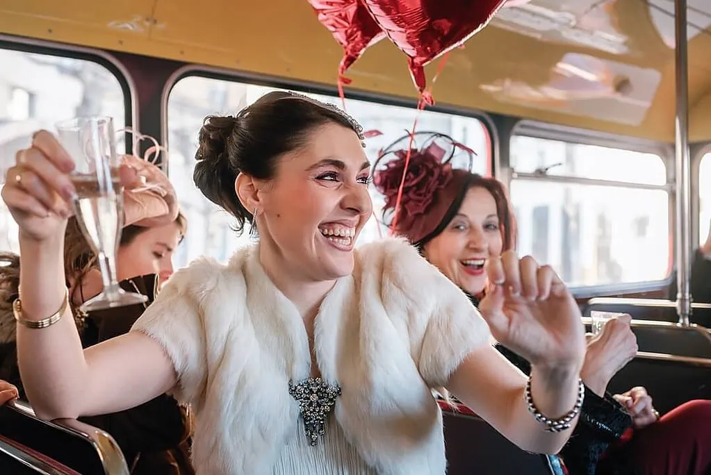 happy bride on a red London bus