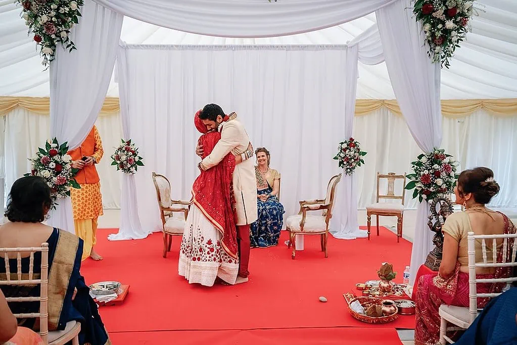 hugs after the exchange of garlands at the Indian wedding ceremony