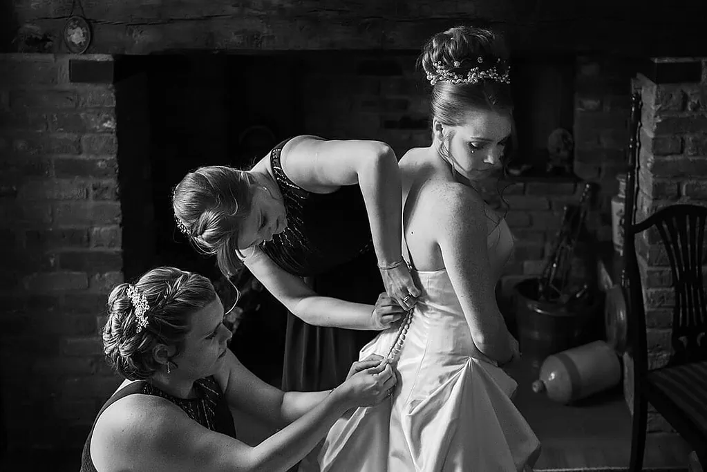 bride having her dress buttoned up