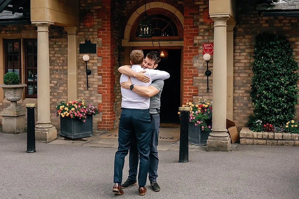 groom embracing guest at Pennyhill Park Wedding