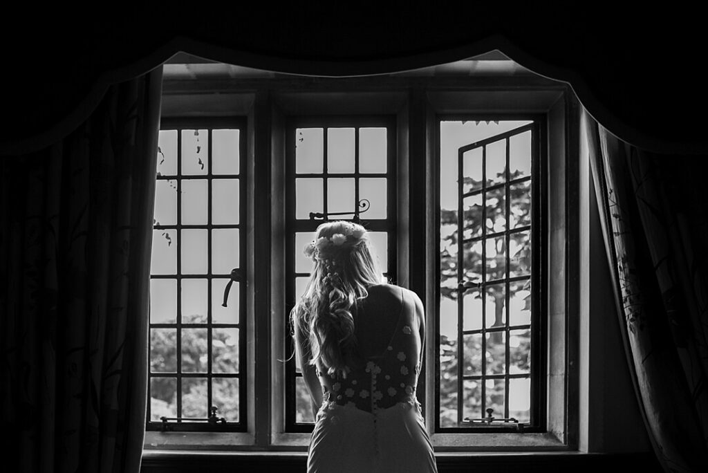 bride looking out of the window at the wedding guests