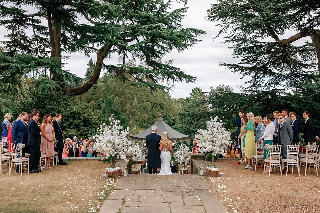 bride walking down the aisle during the wedding ceremony at Pennyhill Park