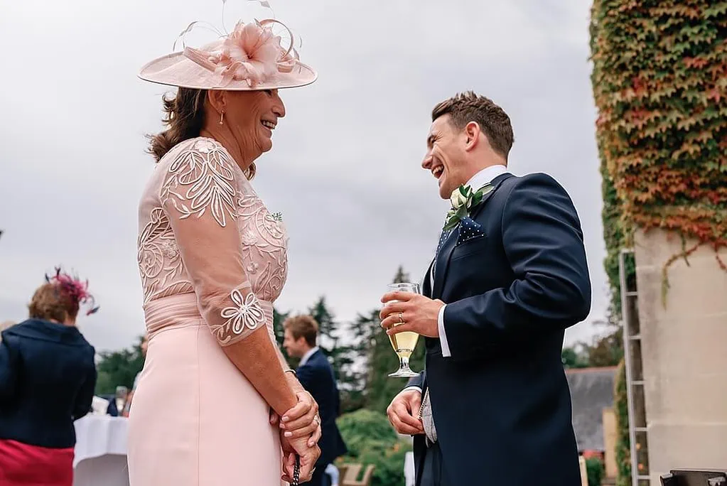 groom and his mum joyful laughter at Pennyhill Park