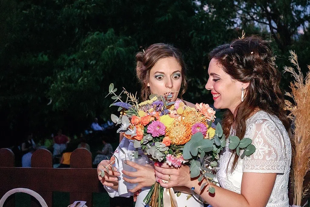 bride giving her best friend the wedding bouquet in Finca el Venero