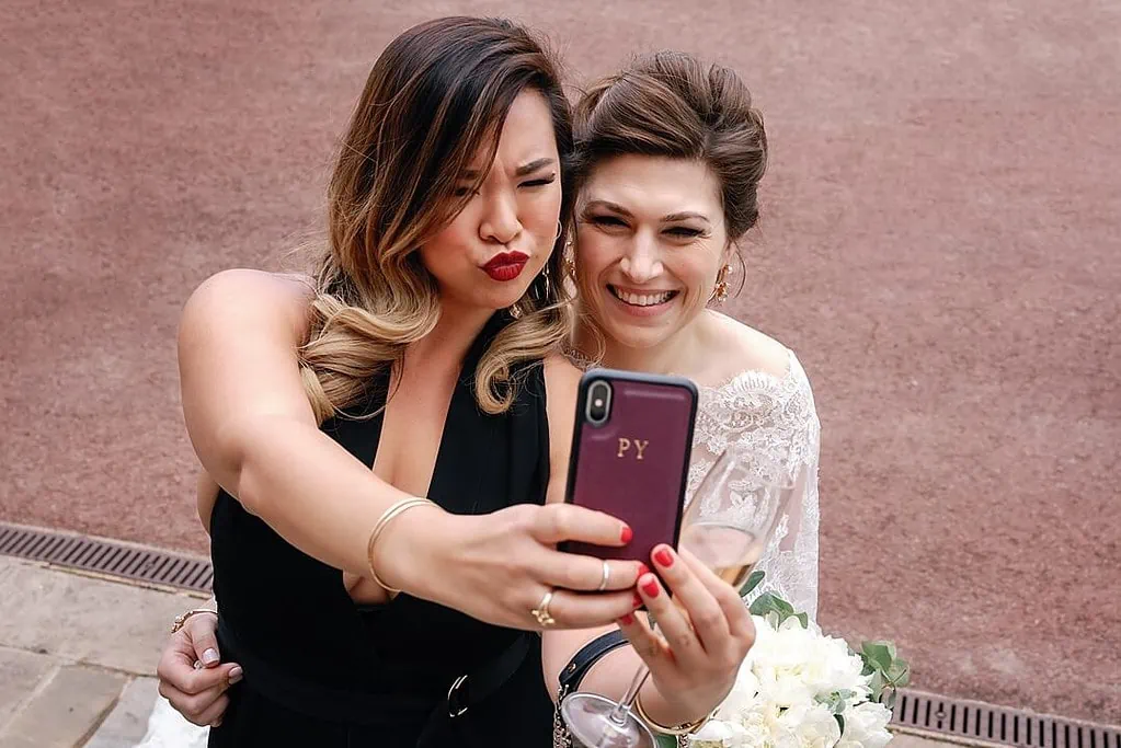 bride taking a selfie with a friend at the wedding