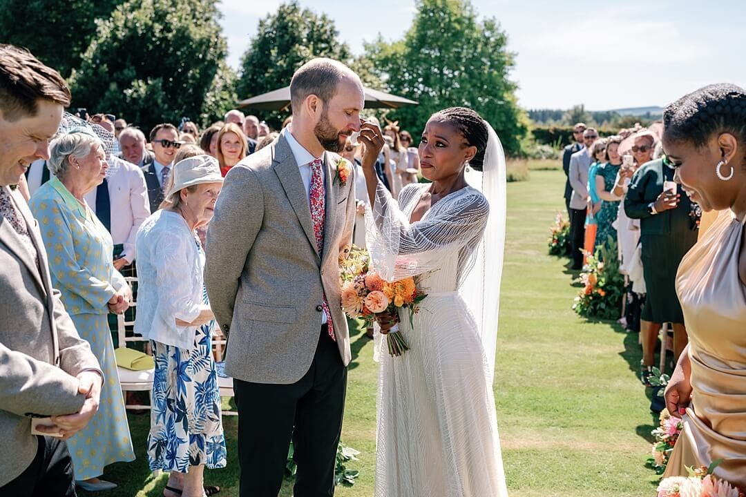 the bride wiping away the groom's tear