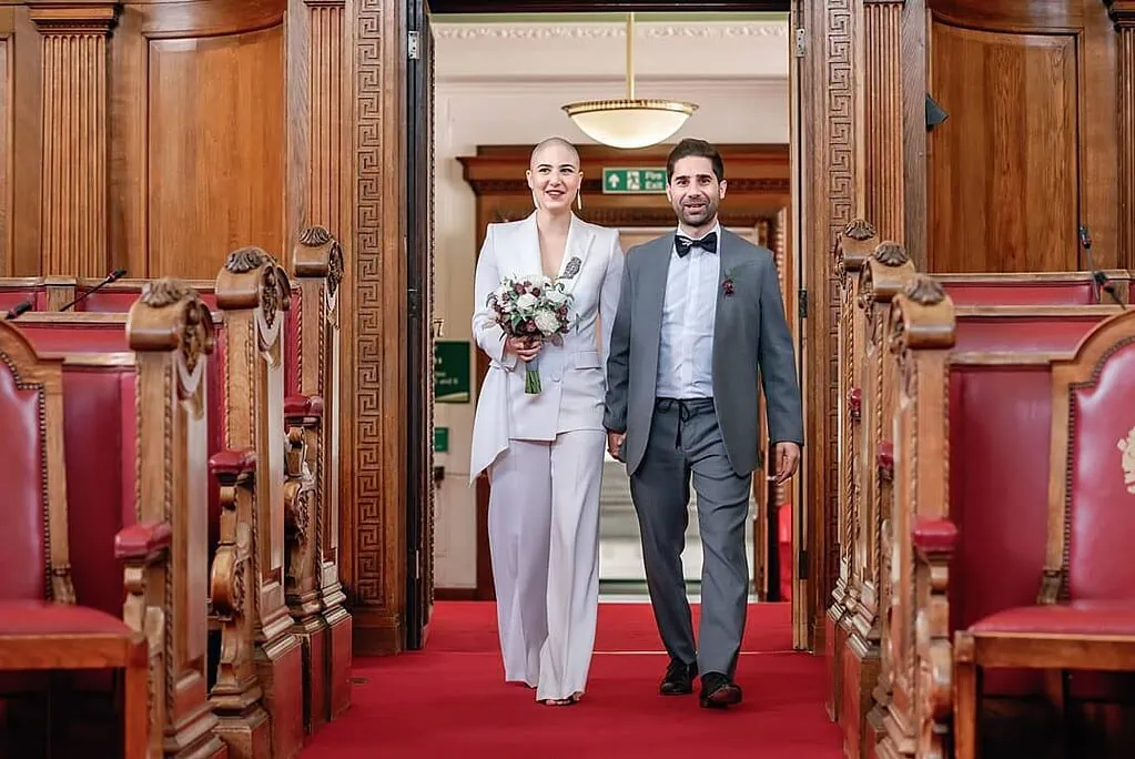 the bride and groom walking into the Council Chamber for their wedding