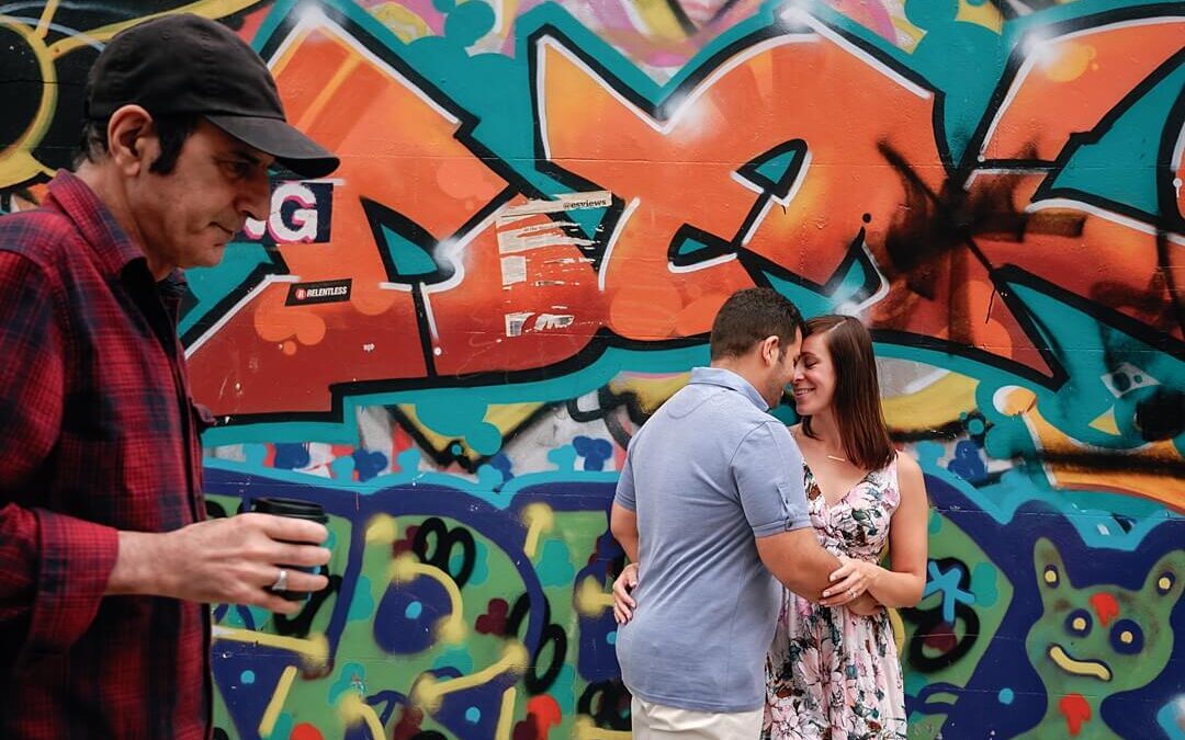 the couple posing in front of a graffiti wall in Notting Hill