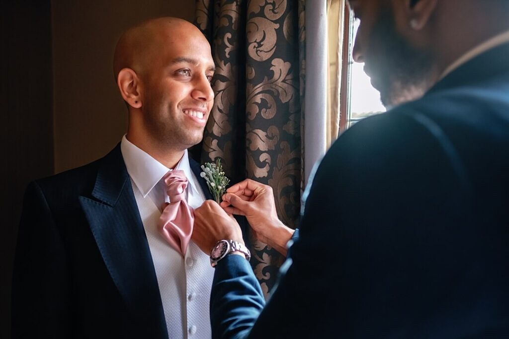 the groom getting ready for the wedding ceremony at The Mere